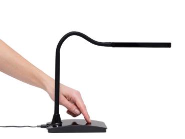 Preview: Hand berührt die flache Basis einer schwarzen, flexiblen Schreibtischlampe mit gebogenem Arm.