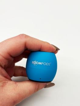 Preview: Eine Hand hält den Lautsprecher, wodurch man sieht, wie klein der Speaker ist.