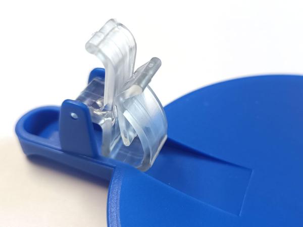 Das Bild zeigt die Unterseite eines Klappdeckels mit dem Kunststoff-Clip, der am Gefäß befestigt wird.