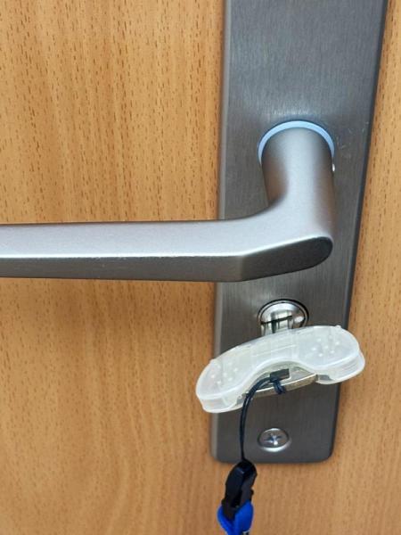 Ein Schlüssel mit Schlüsseldrehhilfe steckt in einem Türschloss.
